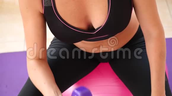 这位女士用健身球特写慢动作训练运动时腹部皮肤的运动视频的预览图