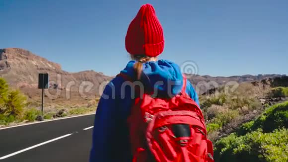 旅行者女人搭便车在阳光明媚的道路上行走背包客女人想搭车开始一段旅程视频的预览图