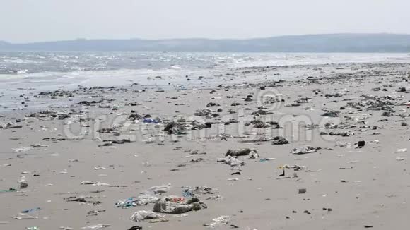 沙滩上塑料垃圾和垃圾桶的拍子视频的预览图