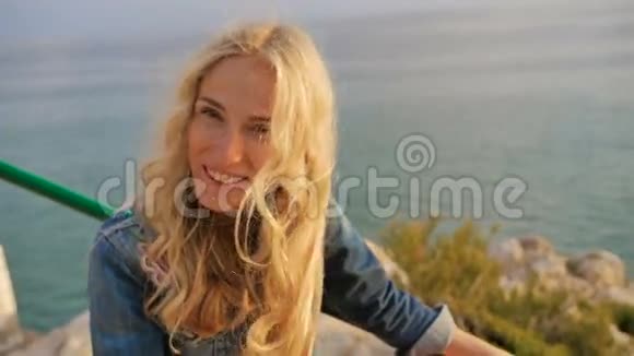 浪漫的金发女孩微笑和笑海滩附近的海岸景观视频的预览图