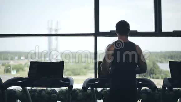 人在跑步机上奔跑的剪影看着大窗户向左向右视频的预览图