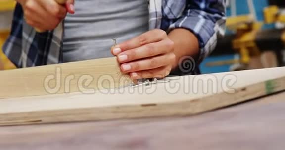 专注于木工在木板上的锤击视频的预览图