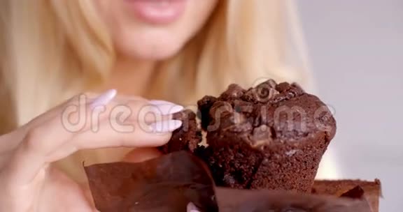 女人手拿着一块巧克力蛋糕视频的预览图