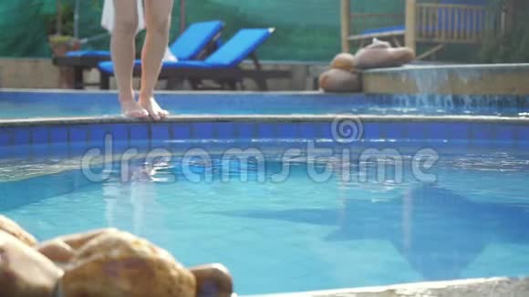 穿着粉红色比基尼的年轻苗条女子缓慢地跳入游泳池在美丽的波克身上泼水视频的预览图