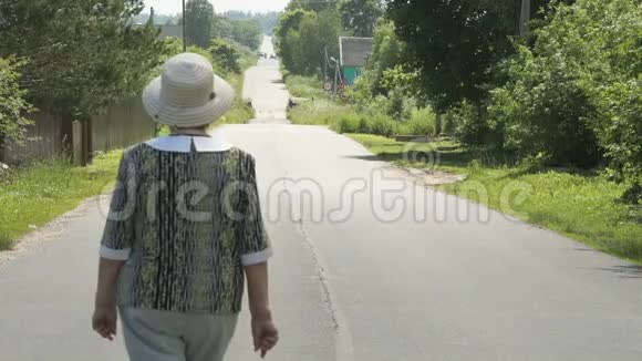 阳光明媚的一天老妇人在路上散步视频的预览图