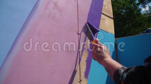 女性手工油漆木墙蓝色使用油漆滚筒用白色油漆辊屋油漆木材视频的预览图