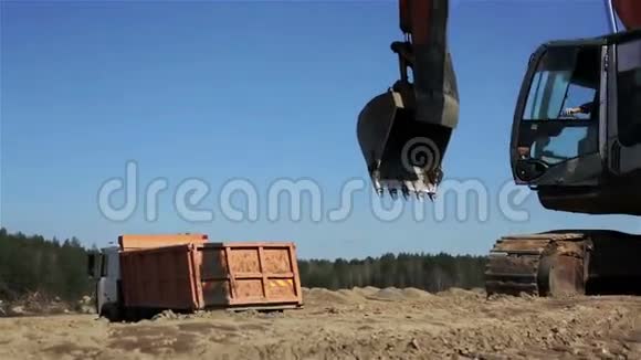 带有橙色车身的自卸汽车倒车装载土壤视频的预览图