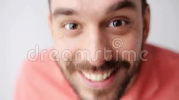 带胡子的快乐微笑男人在镜头前玩视频的预览图
