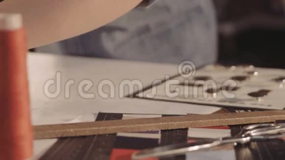 时装设计师画画女人的手在纸上裁剪图案特写视频的预览图