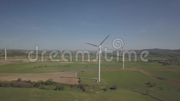 春季白天在风力发电站附近飞行发电机的旋转叶片生态清洁电力视频的预览图