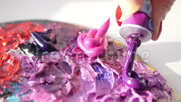 艺术家从管子挤压到调色板紫色油性油漆4k视频的预览图
