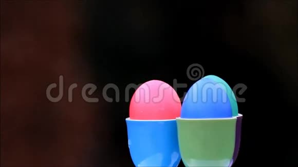 五颜六色的复活节彩蛋放在五颜六色的蛋杯里视频的预览图