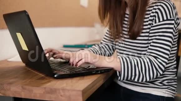 在现代的创业办公室里年轻漂亮女孩的双手特写使用笔记本电脑视频的预览图