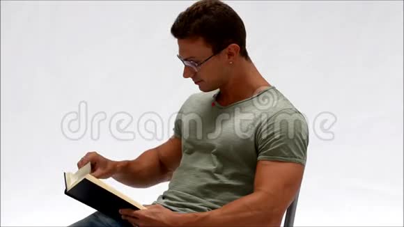 有魅力的年轻人读着书笑着被他看到的东西逗乐视频的预览图