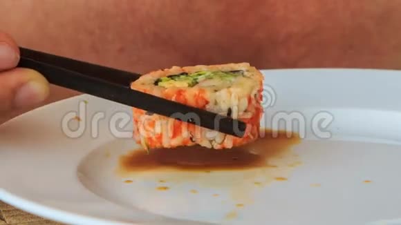 特写男人用盘子里的棍子取寿司视频的预览图