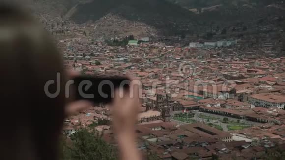 旅游妇女用相机拍摄旅游照片概述城市库斯科从后面看视频的预览图