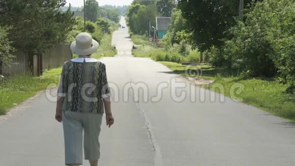 村里走在路上的一位老年妇女视频的预览图