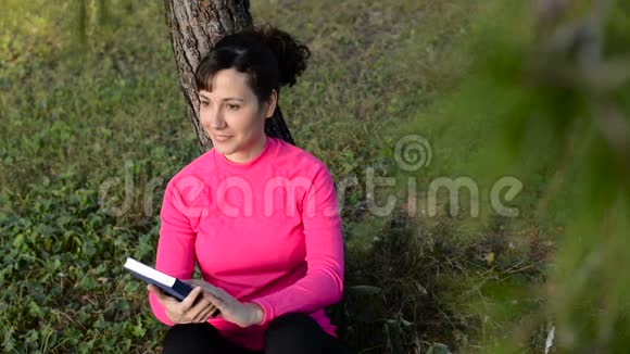 高加索女人在公园看书视频的预览图