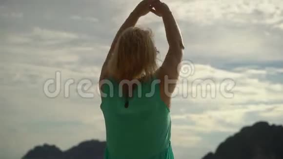 一个女人独自走在狂野的海滩上举起双手视频的预览图