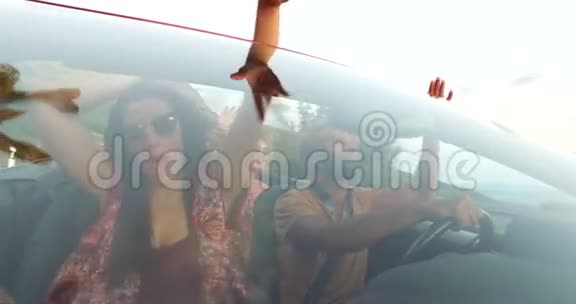 年轻的多民族朋友乘坐红色敞篷车的前景视频的预览图