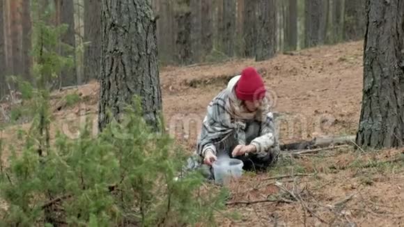 秋天寒冷的天气里一个年轻的女人在森林里采摘浆果视频的预览图