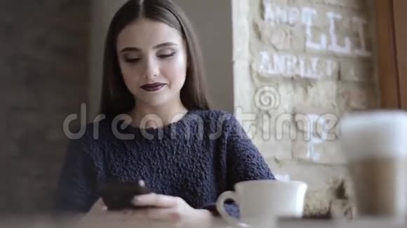 有智能手机的女人在咖啡厅喝咖啡视频的预览图