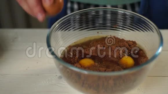 厨师手碎鸡蛋加入玻璃碗准备自制蛋糕视频的预览图
