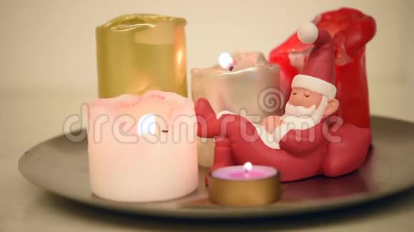 美丽的点燃的圣诞蜡烛和一个小小的沉睡的圣诞小雕像的视频选择性的焦点视频的预览图