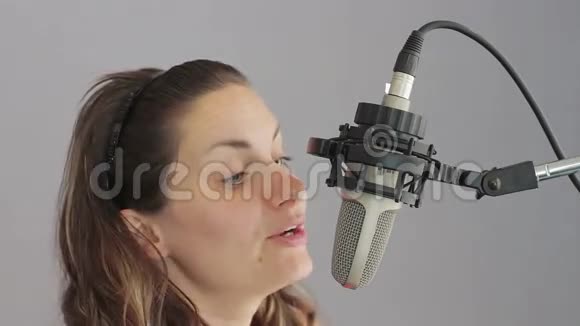 女孩在演播室麦克风里唱歌视频的预览图