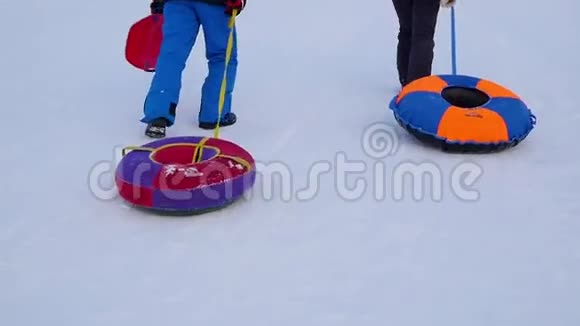 一家人用雪管升到雪山慢动作冬天的雪景日落时间视频的预览图