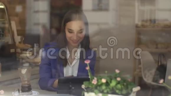 女商人在咖啡馆的平板电脑上工作视频的预览图