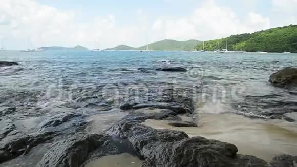 敖延海滩的海岸线风光低角度的海浪冲刷在岩石上安达曼海与游艇视频的预览图