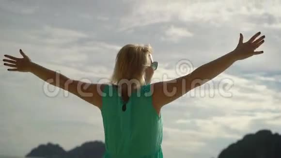 一个女人独自走在狂野的海滩上举起双手视频的预览图