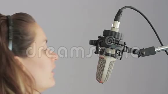 女孩在演播室麦克风里唱歌视频的预览图
