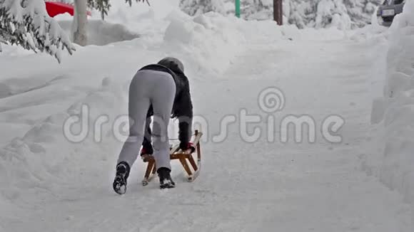 女孩在雪地上拉着雪橇视频的预览图