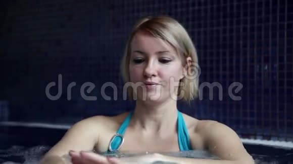 泳池里穿着蓝色比基尼的年轻女人在说话视频的预览图