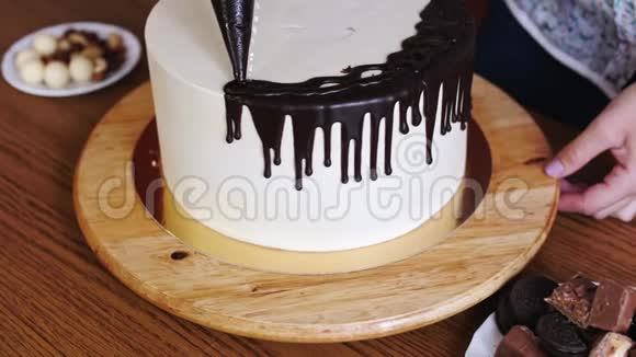 女人手的特写准备一个蛋糕把巧克力奶油倒在上面视频的预览图