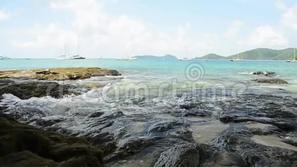 敖延海滩的海岸线风光低角度的海浪冲刷在岩石上安达曼海与游艇视频的预览图