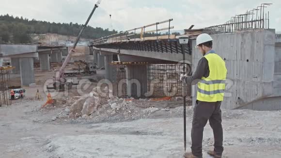 在大型建筑工地使用GPS测量装置的建筑工程师视频的预览图