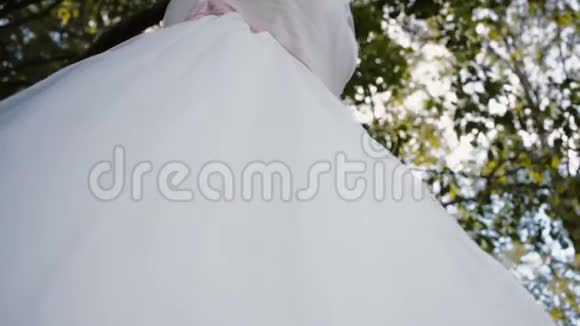 白色蕾丝婚纱挂在树枝上视频的预览图