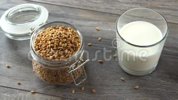 新鲜的自制面包麦粒和牛奶放在乡村的木桌上自然健康的饮食视频的预览图