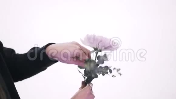 一个女花店把一束紫色和粉红色的花收起来视频的预览图