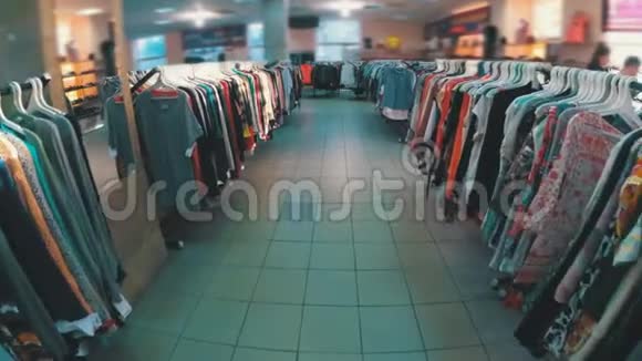 挂在衣架上的一排排挂在二手商店里购物中心内的景观视频的预览图