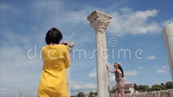 幸福的女人在古城遗址背景上用智能手机拍照女朋友视频的预览图