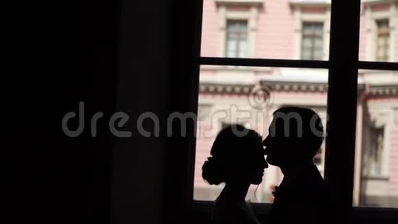 可爱的情侣在城市里亲吻拥抱的剪影视频的预览图