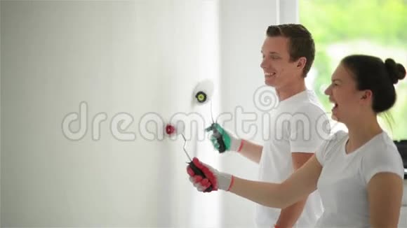 年轻夫妇装饰他们的新公寓他们正在粉刷墙壁视频的预览图