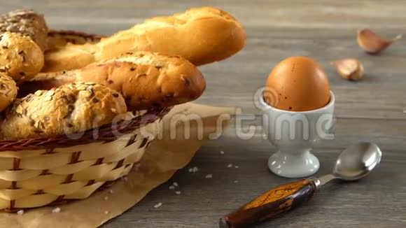 牛奶黄油饼干鸡蛋和新鲜面包放在乡村木桌上乡村早餐视频的预览图