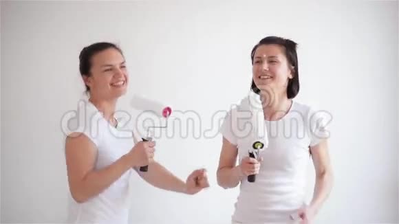 两个女孩在油漆滚筒里唱歌朋友们正在修理和跳舞视频的预览图