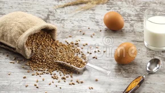 一堆小麦牛奶鸡蛋和新鲜的面包放在乡村的木桌上乡村早餐视频的预览图