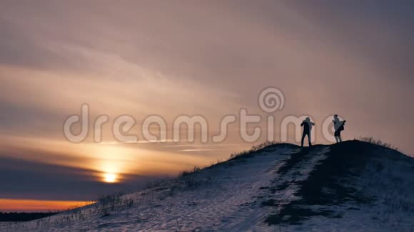 人们冬日剪影照喜雪阳一群游客走在夕阳的剪影山上视频的预览图